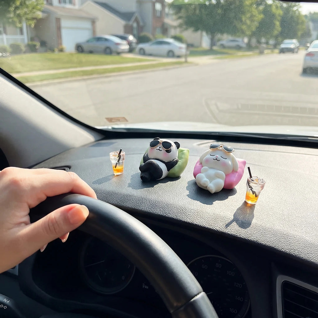 Panda and bunny figurines on car dashboard