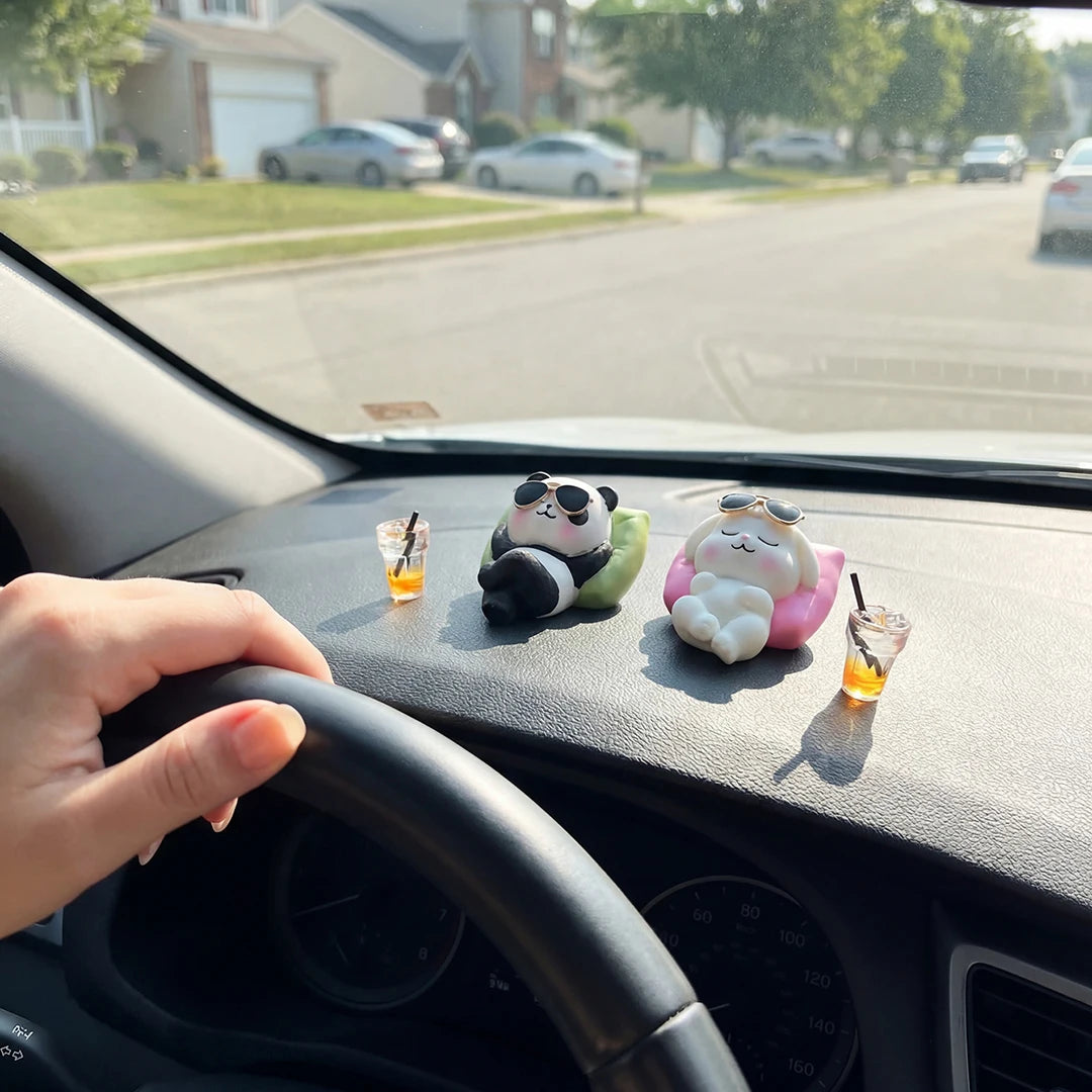 Panda and bunny figurines on car dashboard